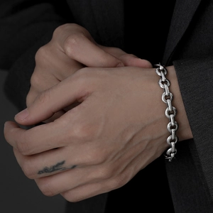 Makro-Detail des silbernen Schweinenasen-Kettenarmbands für Herren im Industrial-Stil