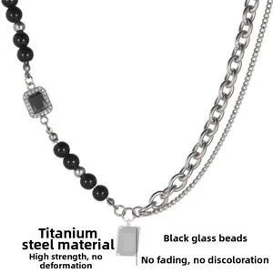 Detail view of titanium steel necklace with black glass beads and rectangular gemstone charm