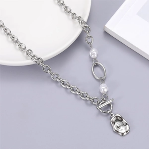 Detail of silver link chain necklace with irregular pleated metal pendant and pearls