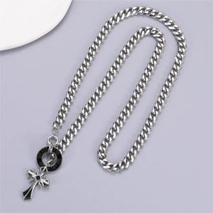 Detailed view of silver Cuban chain necklace with cross pendant and Never Say Die engraving