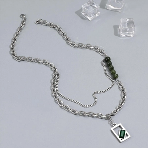 Detail of double-layer stainless steel necklace with green beads and rectangular pendant