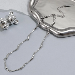 Vue détaillée d'un collier argenté aux maillons ondulés irréguliers et finition polie