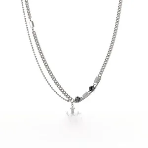 Detailed view of layered titanium steel cross necklace with cuban link and crystal stones