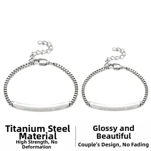 Detail of silver titanium steel couple bracelets featuring 'you complete me' engraving