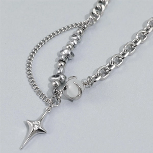 Detailed close-up of layered titanium steel necklace with star pendant and cat-eye bead