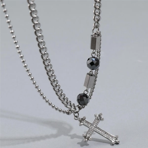 Detail of hip hop silver necklace showing Cuban chain with a cross pendant