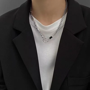 Gros plan d'un collier pour homme en acier titane avec perle noire porté par un mannequin
