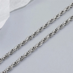 Détail rapproché d'un collier chaîne torsadée argentée à texture polie luisante