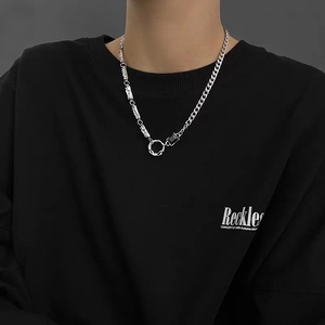 Détail du collier en chaîne argentée avec pendentif pierre noire sur un mannequin homme