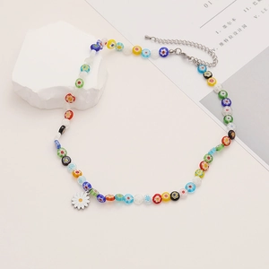 Detailed close-up of colorful beaded floral necklace with small daisy pendant and clasp