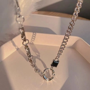 Détail de la chaîne cubaine argentée avec pierre onyx noire et pendentif anneau irrégulier