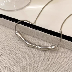 Detail of silver irregular pendant with liquid drop design on delicate snake chain
