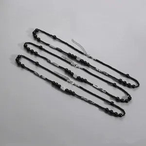 Detail of multi-layer beaded necklace with black round beads and irregular gray stones
