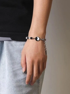 Dettaglio del bracciale Yin Yang Tai Chi con perline nere e argento indossato al polso