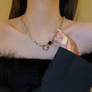 Gros plan d'un collier hip-hop en acier titane avec chaîne asymétrique et pendentif noir