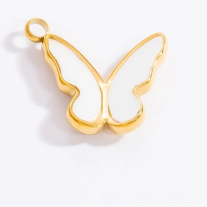 Vue macro d'un pendentif papillon doré avec émail blanc et anneau de suspension
