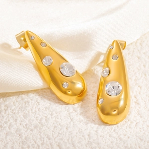 Macro shot of gold-plated teardrop earrings with sparkling round zircon crystals