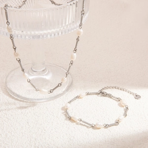 Detailed view of silver freshwater pearl necklace and bracelet set with S925 engraved charm