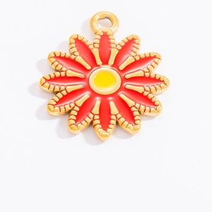 Détail macro du pendentif marguerite avec émail rouge et jaune sur base dorée