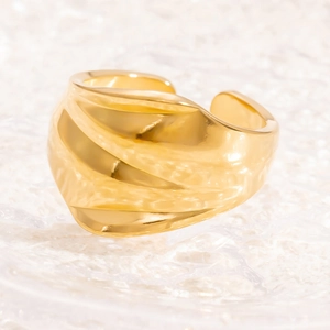 Macro di anello largo dorato con trama a onde irregolari su uno sfondo trasparente