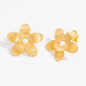 Detail of gold flower stud earrings featuring textured petals and a center pearl