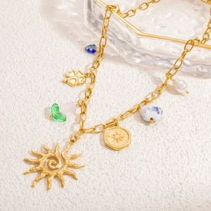 Détails du collier plaqué or 18k avec breloques soleil et trèfle ajouré