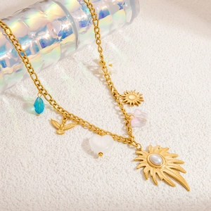Détail du collier bohème plaqué or 18k avec cristal bleu et pendentifs soleil