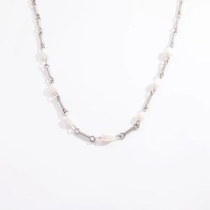 Detail of silver-toned metal necklace featuring textured tube links and freshwater pearls