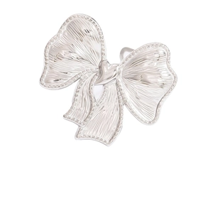 Polished stainless steel ring featuring a large pleated bow design with a heart centerpiece