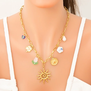 Détail du collier chaîne plaqué or 18k avec breloques vintage et perle irrégulière
