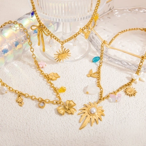 Collier bohème or 18K avec fleurs en perles, nœud papillon et pendentifs soleil variés