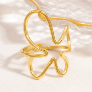 Macro detail of a large hollow flower gold open ring with minimalist abstract line design