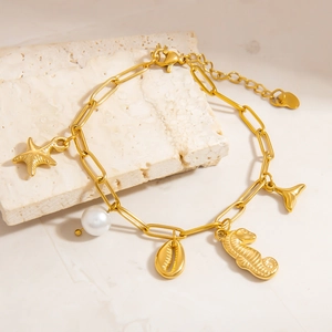 Détail du bracelet chaîne en or 18K avec breloques d'étoile de mer et de perles