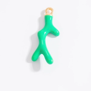 Dettaglio di un ciondolo a corallo verde smaltato con gancio dorato per gioielli