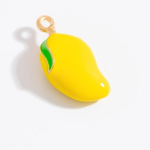Dettaglio ravvicinato di un ciondolo a forma di mango giallo con foglia verde e gancio d'oro