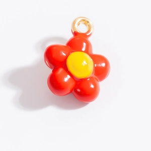 Dettaglio del ciondolo a fiore in smalto rosso e giallo con anello in lega dorata