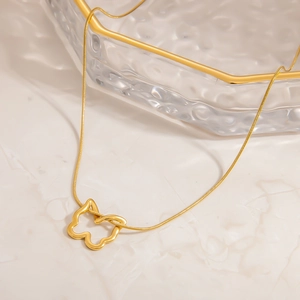 Elegante goldene Schmetterlings-Halskette mit Schlangenkette auf Marmoroberfläche