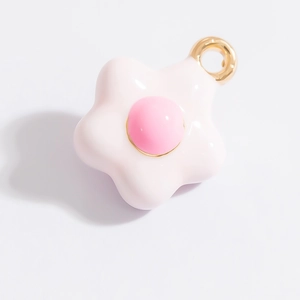 Dettaglio di un ciondolo a fiore rosa con anello dorato per la creazione di gioielli