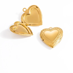 Detail of vintage 18K gold plated heart locket pendant with ornate floral engraving