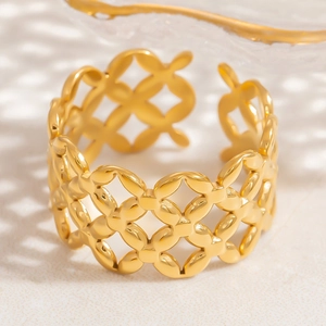 Makroaufnahme Goldener Breiter Ring mit hohlem Kleeblattmuster auf Steinoberfläche