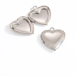 Macro detail of open heart locket pendant in polished steel with floral engraving