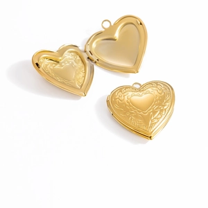 Detailed macro view of heart locket pendant with floral relief and open inner compartments
