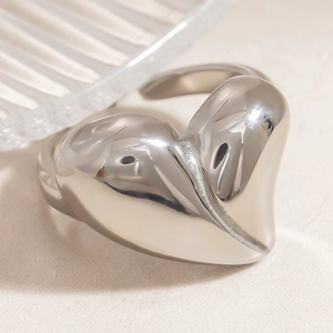 Macro detail of polished silver heart-shaped ring with high-gloss mirror finish and modern style