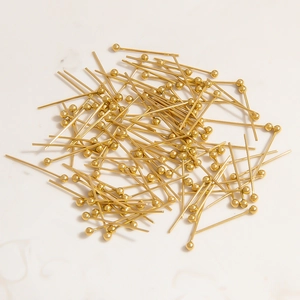 Detailed close-up of shiny gold-plated ball head pins for DIY jewelry making material