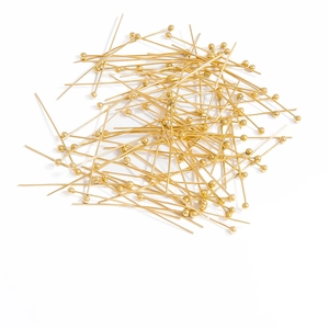 Detailed close-up of shiny gold-plated ball head pins for professional DIY jewelry making
