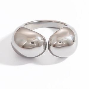 Close-up of a silver open ring with polished teardrop ends and a minimalist design