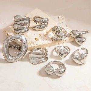 Minimalist silver fluid heart rings and irregular lava bands on marble display stone