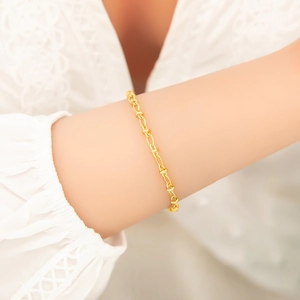 Detaillierte Nahaufnahme von vergoldetem Armband mit gedrehten Gliedern und Struktur