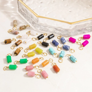 Macro detail of various cylindrical natural stone pendants with gold wire wrapping