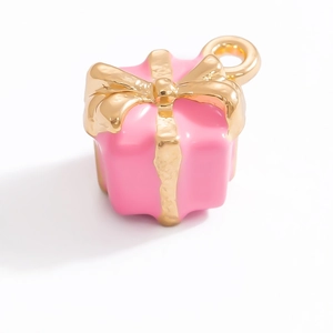 Detail view of pink enamel gift box pendant with golden bow for DIY jewelry making